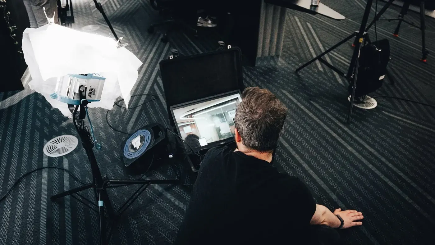 Lewis Rees at the monitor, with lights and stands around him