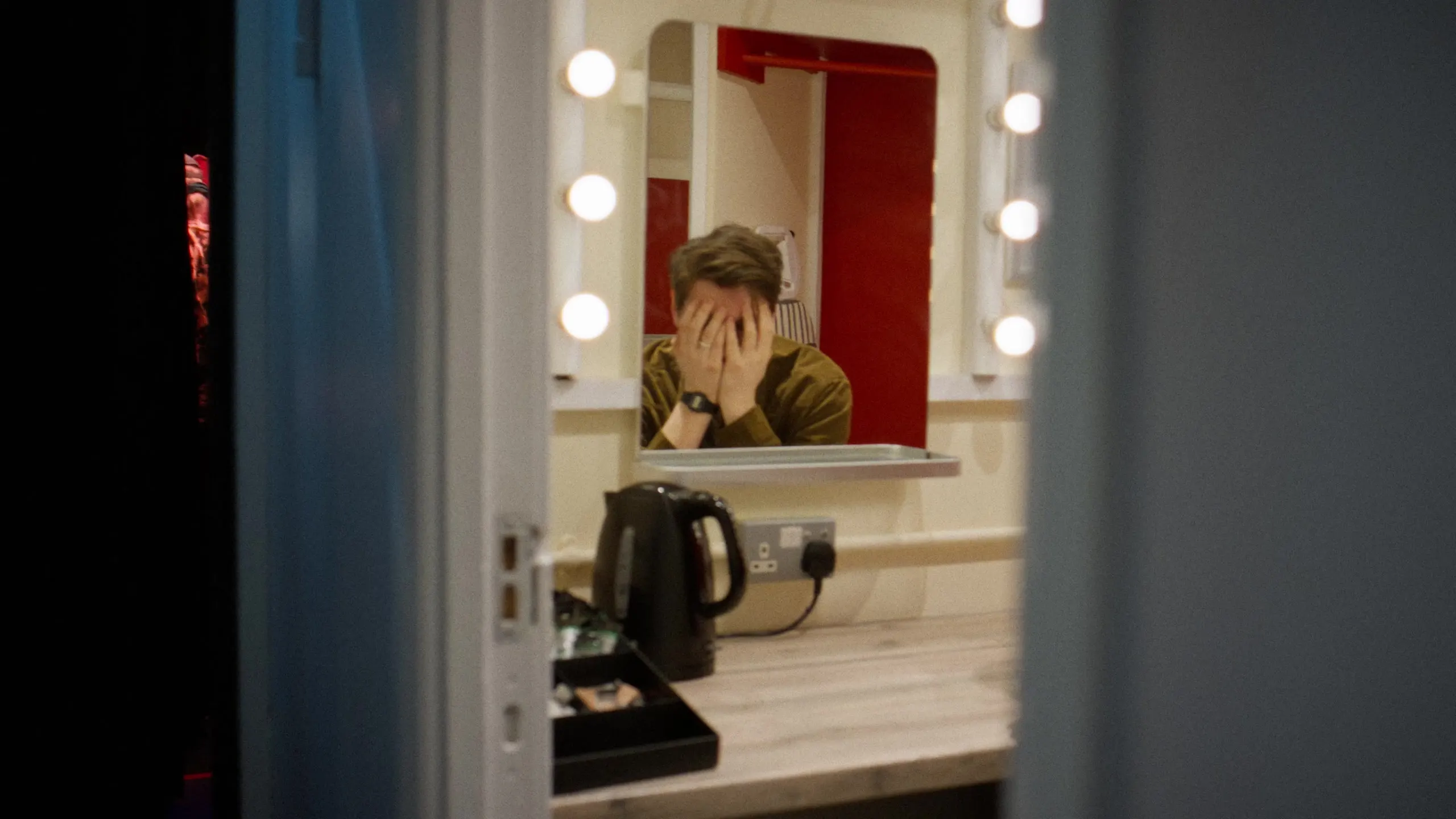 Sean McLoughlin in the dressing room, seen through the doorway with his head in his hands