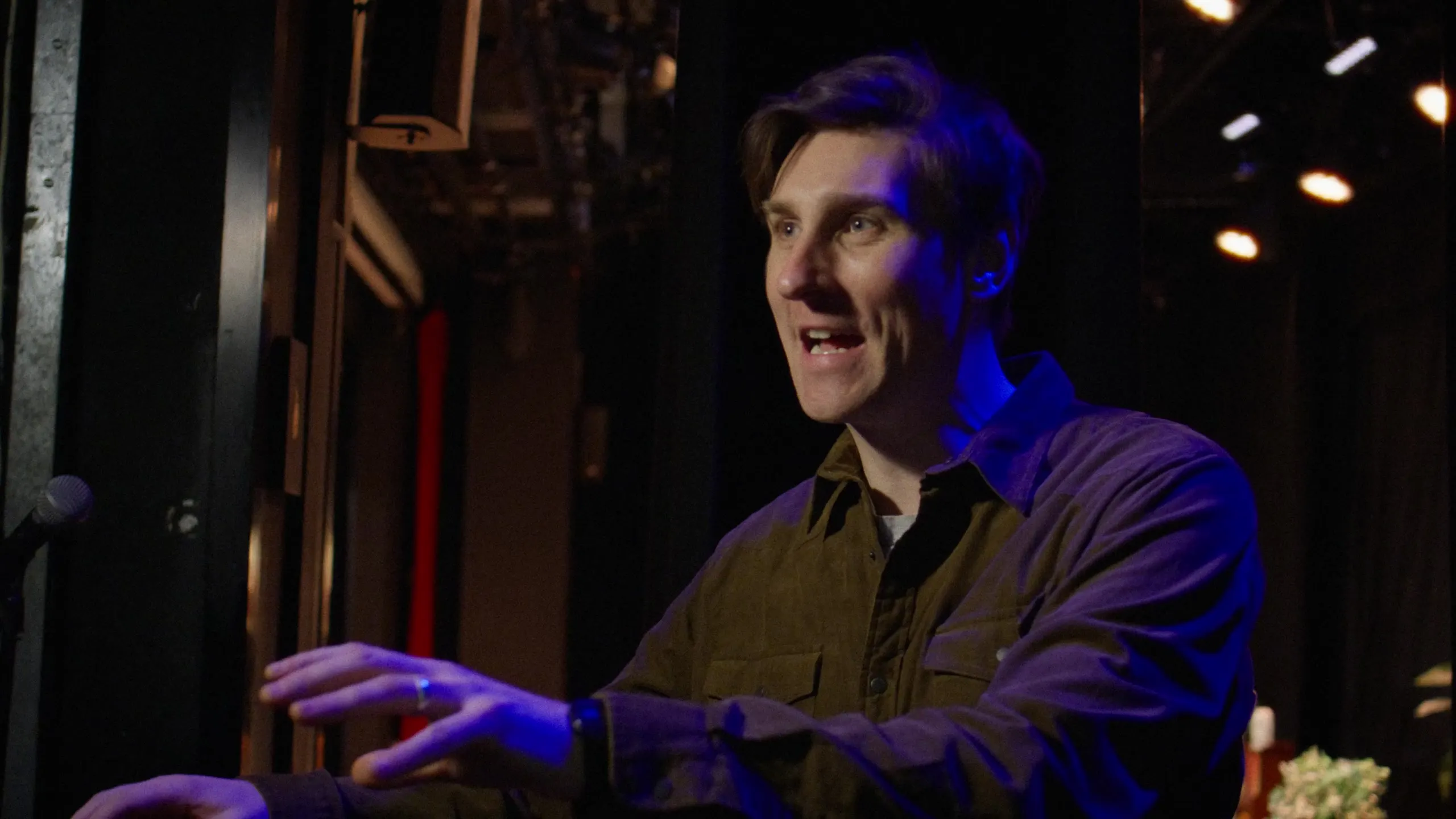 Sean McLoughlin lit in blue in the wings before the show